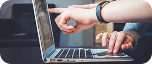 hands pointing to laptop screen